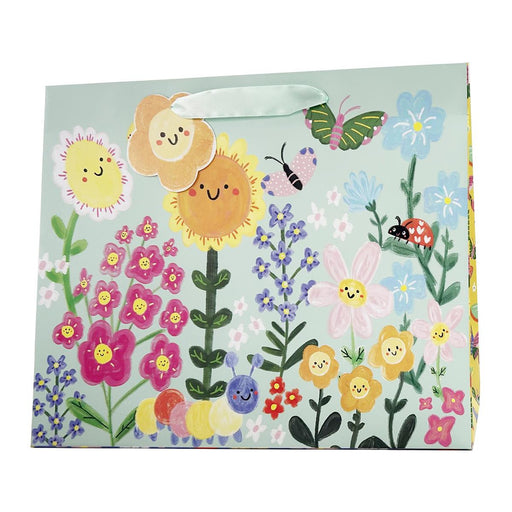 Gift bag with colorful floral design and happy face flowers on a light blue background
