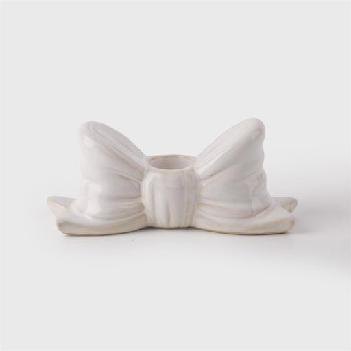White ceramic bow-shaped object on a light gray background