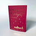 A red rectangular box of 'merry & bright' holiday mix by the brand 'salted.' with gold foil lettering and gold polka dots, photographed on a light gray gradient background.