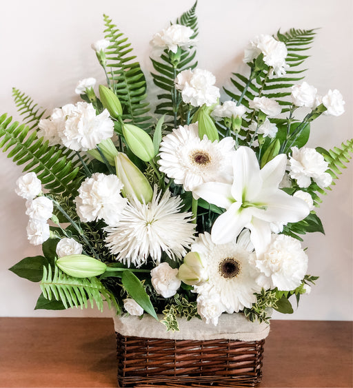 Basket flower arrangement of blended whites and greens